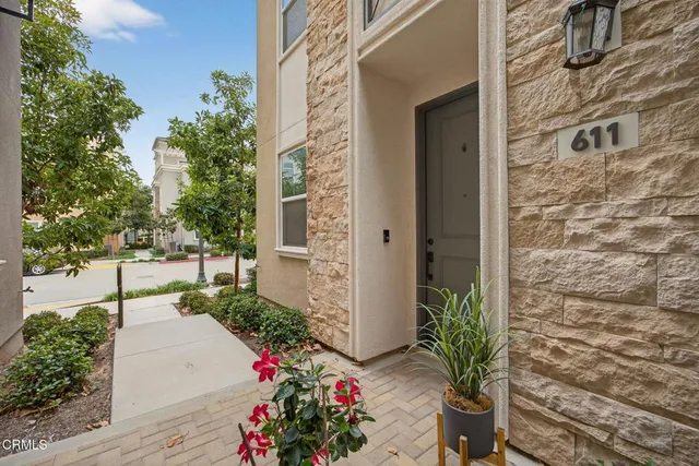 a kitchen with stainless steel appliances granite countertop a sink a stove a refrigerator a microwave and white cabinets