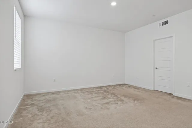 a view of an empty room with a refrigerator