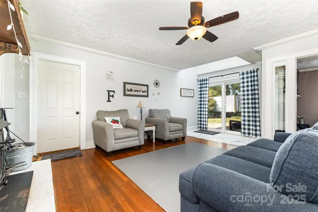 a living room with furniture or chandelier and a wooden floor