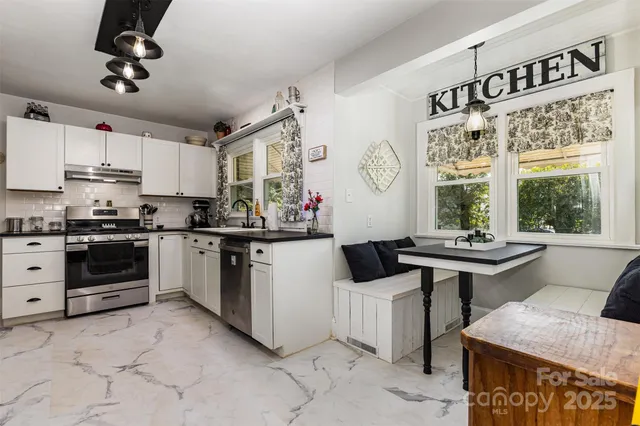 a kitchen with kitchen island granite countertop a sink cabinets and window