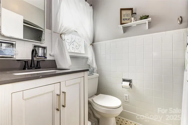 a bathroom with a granite countertop sink a toilet and a shower