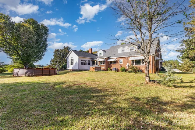 a house view with swimming pool in front of residential houses