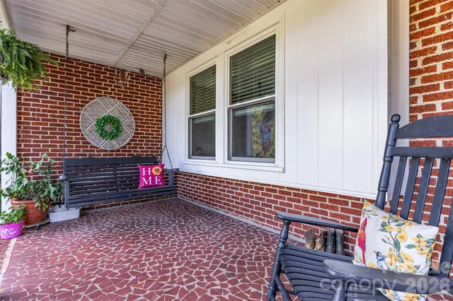 a brick building with a bench and a potted plant