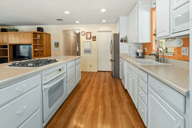 a large kitchen with stainless steel appliances kitchen island granite countertop a refrigerator a stove and a sink with cabinets