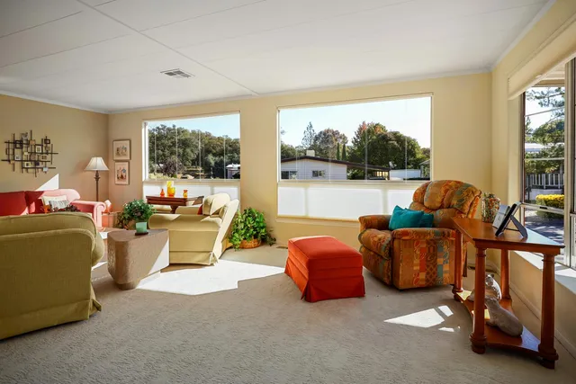 a living room with furniture a fireplace and a large window