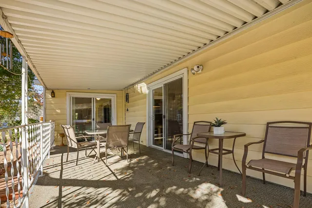 a patio with table and chairs and potted plants