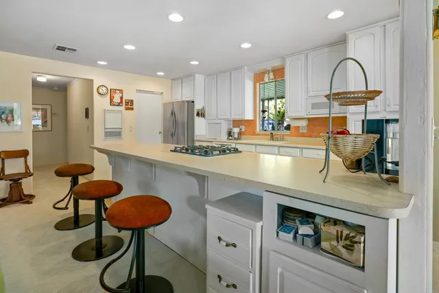 a kitchen with stainless steel appliances granite countertop a counter space a sink and cabinets