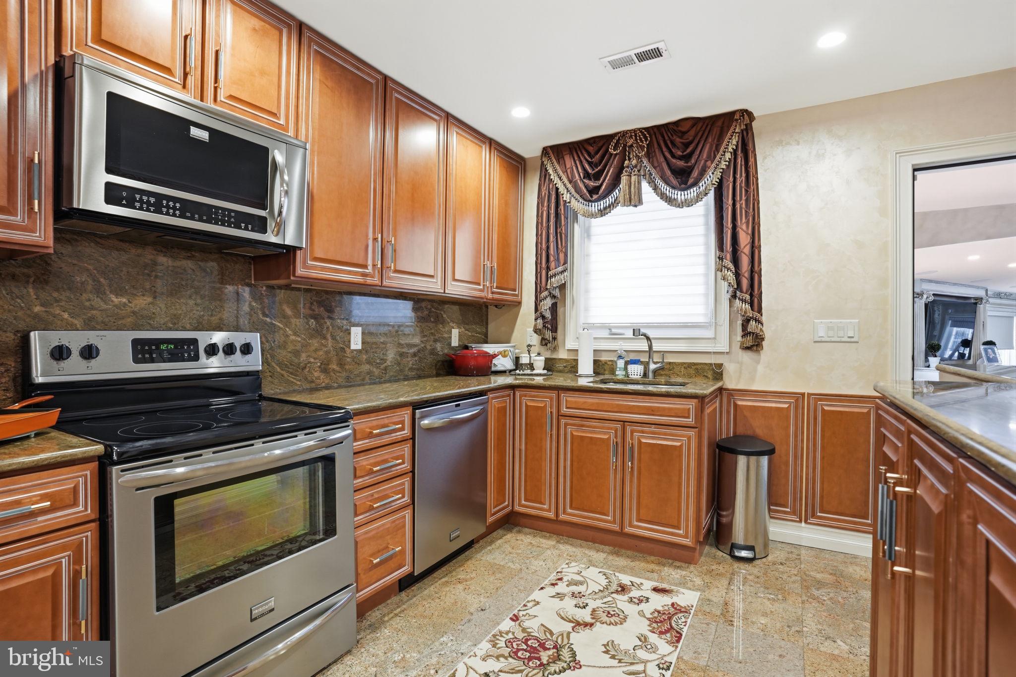 1066 Washington Crossing Road Washington Crossing, PA 18977 - Photo 47 of 92 a kitchen with stainless steel appliances granite countertop a stove microwave sink and cabinets