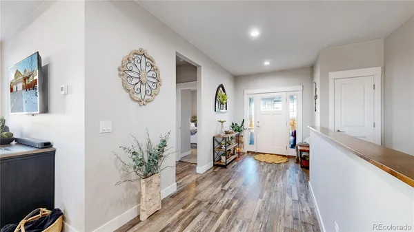 a view of a hallway with furniture and wooden floor
