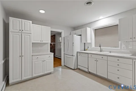 a kitchen with white cabinets and stainless steel appliances