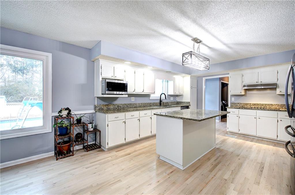 16 High Point Drive Southwest Cartersville, GA 30120 - Photo 14 of 44 a kitchen with granite countertop a stove cabinets and wooden floor