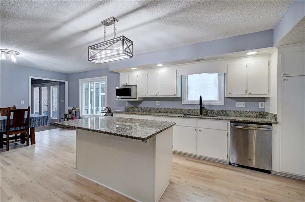 16 High Point Drive Southwest Cartersville, GA 30120 - Photo 15 of 44 a kitchen with stainless steel appliances granite countertop a kitchen island a stove a sink a dining table and chairs