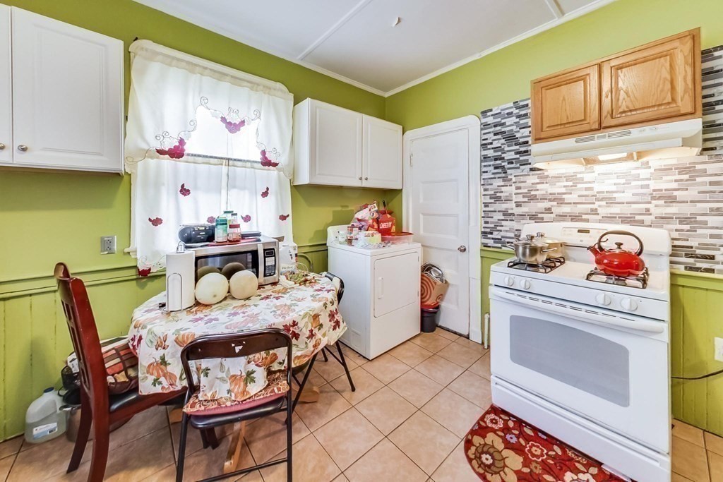 109 Walnut Street Somerville, MA 02145 - Photo 11 of 42 a kitchen with a white cabinets and stove top oven