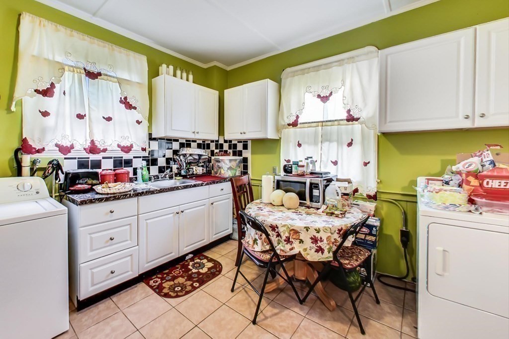 109 Walnut Street Somerville, MA 02145 - Photo 12 of 42 a kitchen with stainless steel appliances kitchen island granite countertop a white cabinets and wooden floor