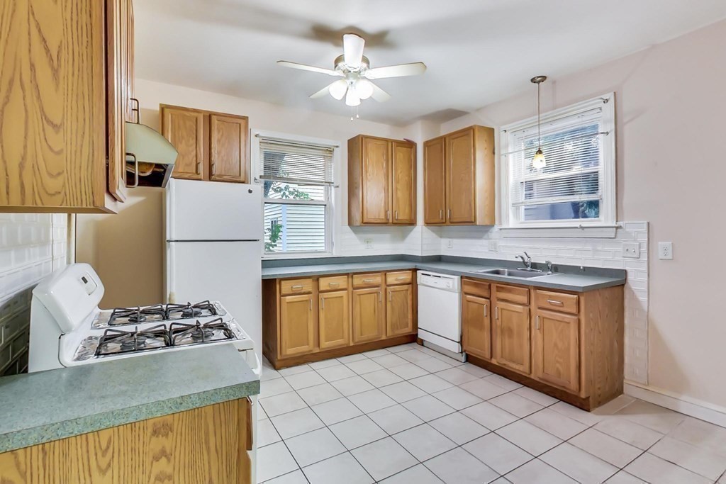 109 Walnut Street Somerville, MA 02145 - Photo 14 of 42 a kitchen with stainless steel appliances granite countertop a sink stove and refrigerator