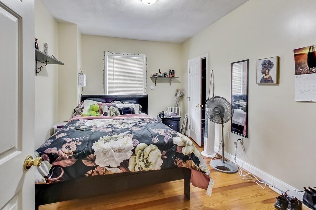 109 Walnut Street Somerville, MA 02145 - Photo 32 of 42 a bedroom with a bed and wooden floor