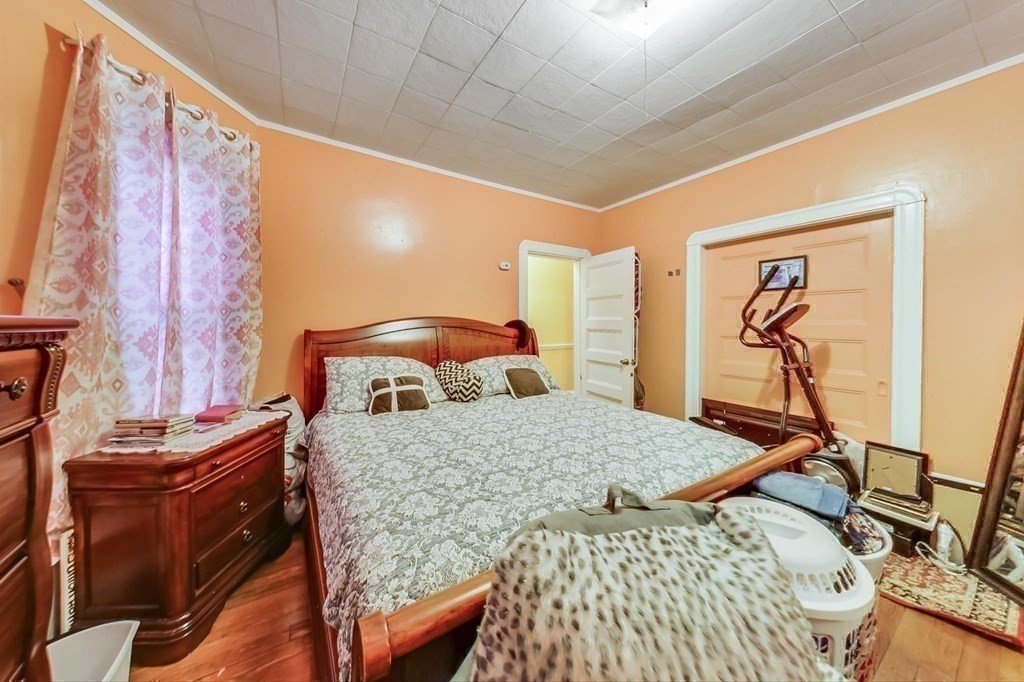 109 Walnut Street Somerville, MA 02145 - Photo 33 of 42 a bedroom with a bed and wooden floor