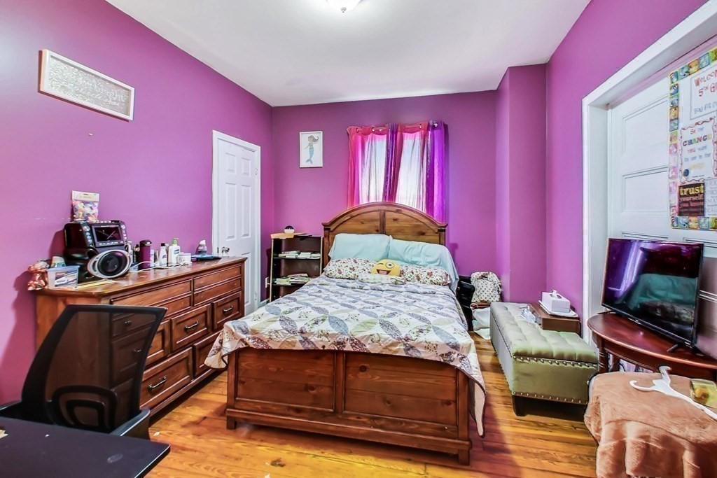 109 Walnut Street Somerville, MA 02145 - Photo 34 of 42 a bedroom with a bed and wooden floor