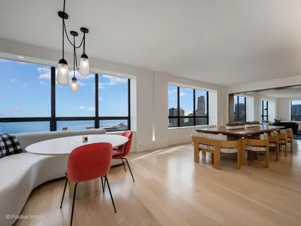 a dining hall with stainless steel appliances kitchen island granite countertop a table and chairs