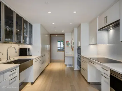 a kitchen with stainless steel appliances a stove a sink and white cabinets