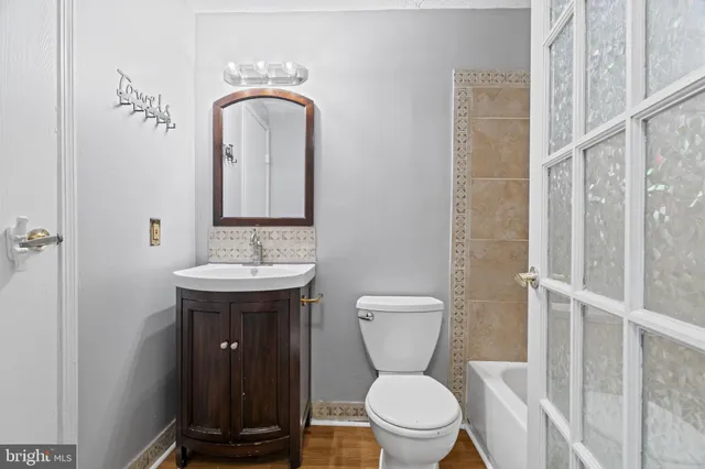a bathroom with a toilet sink and mirror