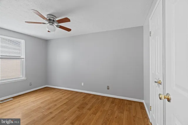 a view of a livingroom with a ceiling fan and wooden floor