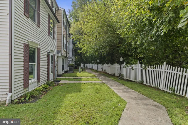 a view of swimming pool with small garden and wooden fence