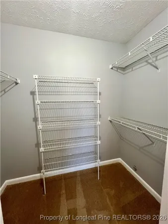 a view of walk in closet with clothes