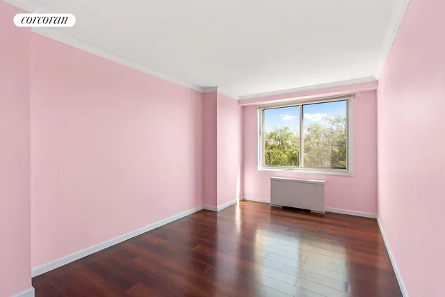 a view of an empty room with wooden floor