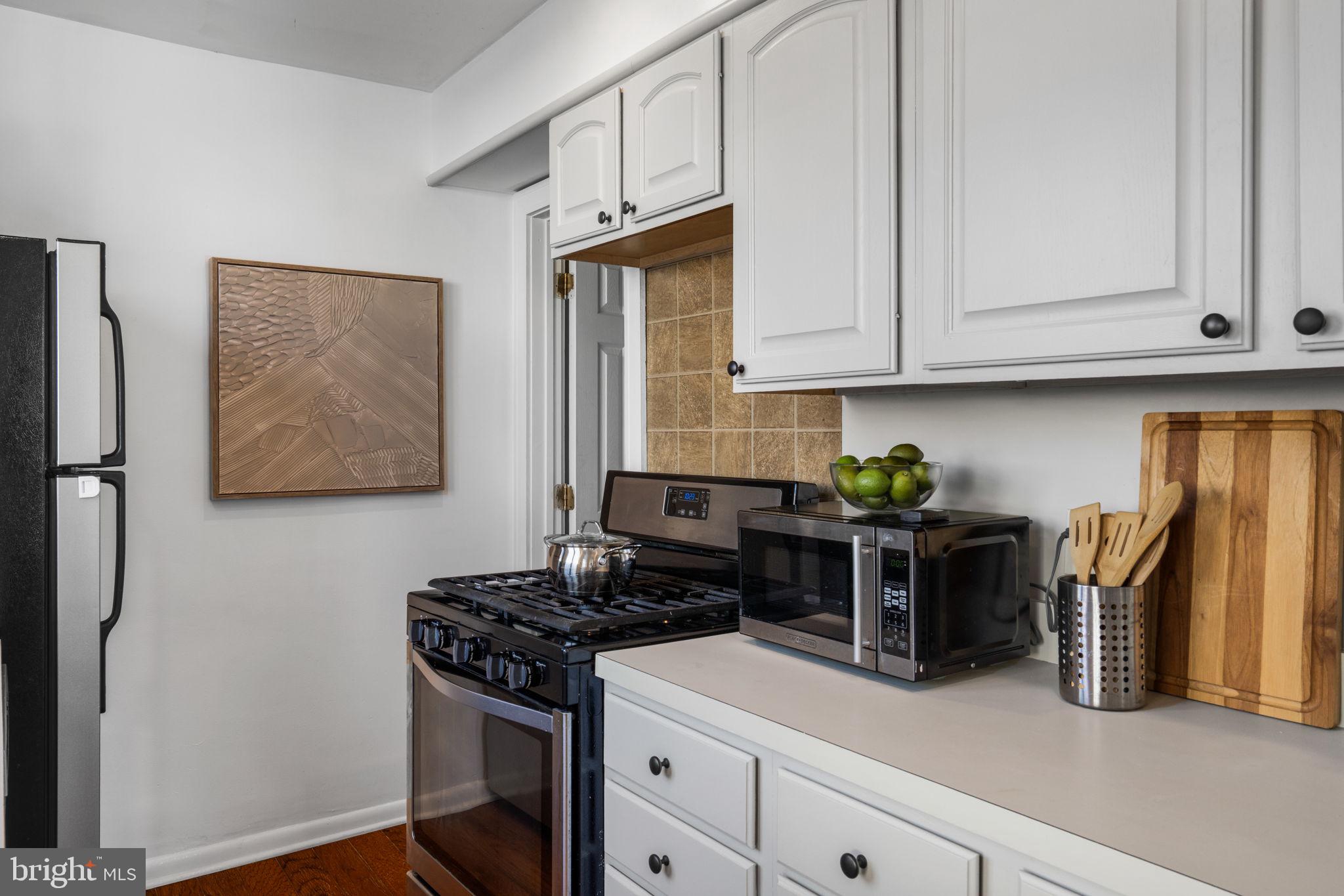 264 Pancoast Avenue Springfield, PA 19064 - Photo 19 of 38 a kitchen with stainless steel appliances granite countertop a stove a refrigerator and a white cabinets
