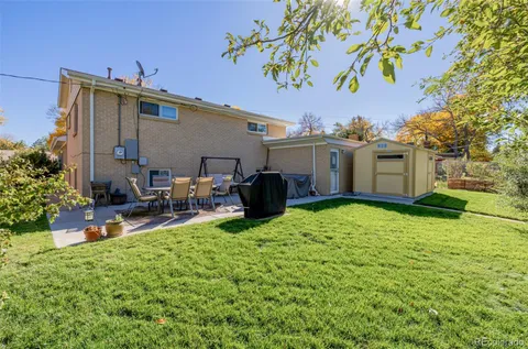 a view of a house with backyard and sitting area