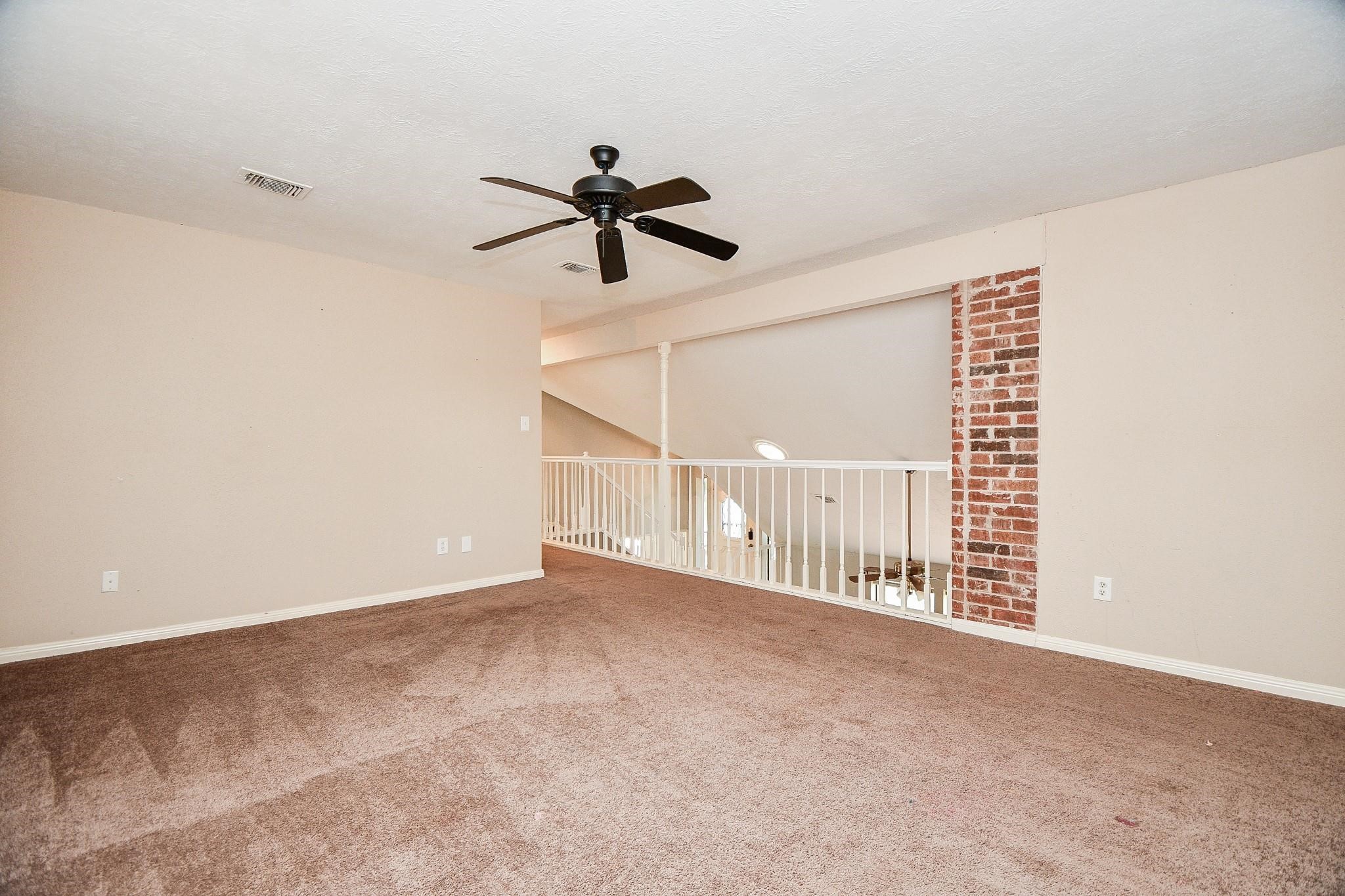 2331 Wren Meadow Road Richmond, TX 77406 - Photo 26 of 37 Time for game night! Enjoy this large gameroom that looks down to the main living area, trimmed with beautiful red brick accents!