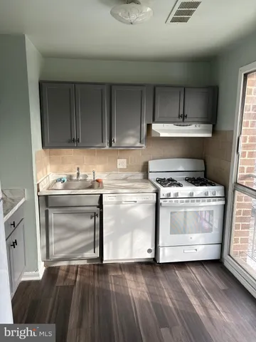 a white refrigerator freezer and a stove sitting inside of a kitchen