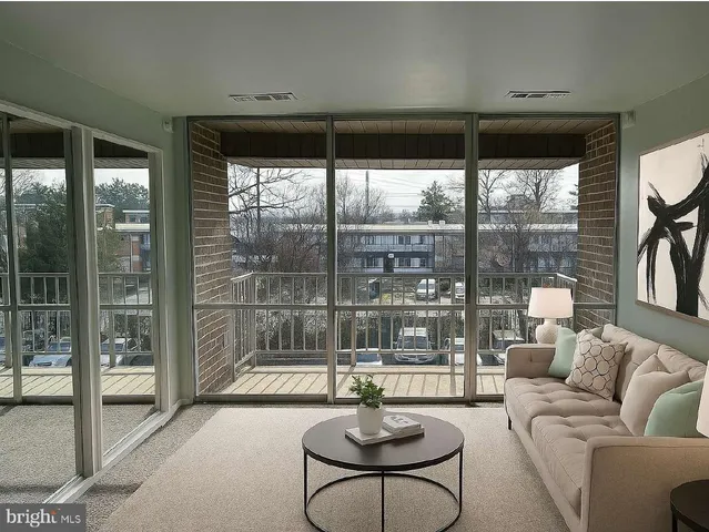 a living room with furniture and a floor to ceiling window
