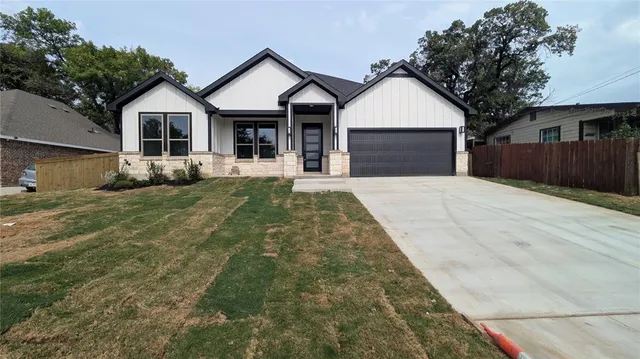a front view of a house with a garden and trees