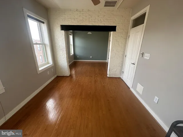 wooden floor in an empty room with a window