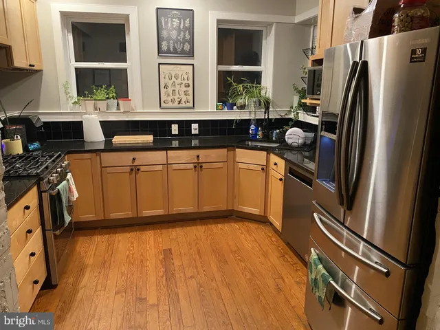 a kitchen with stainless steel appliances granite countertop a refrigerator and a sink