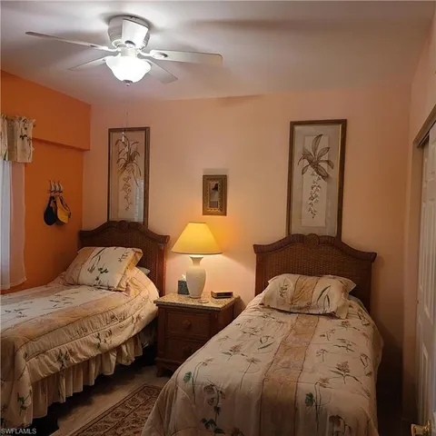 a bedroom with two beds and a chandelier