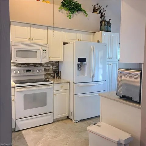 a white refrigerator freezer and a stove sitting inside of a kitchen