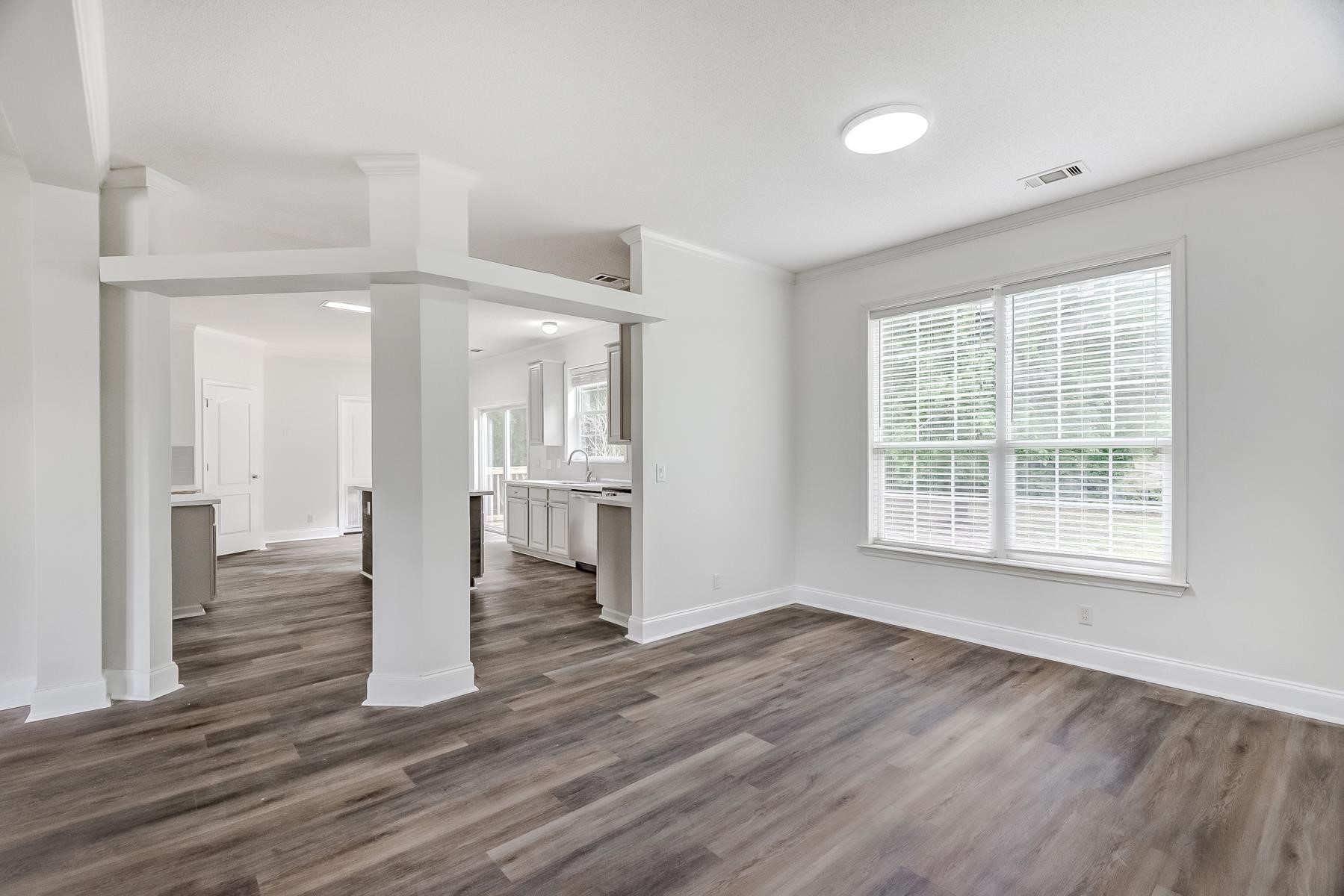 16741 Highway 69 Warren, TX 77664 - Photo 8 of 24 a view of empty room with wooden floor and kitchen view