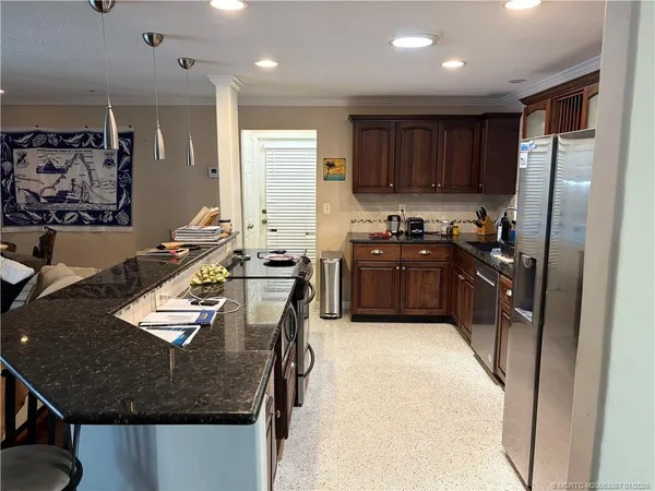a kitchen with stainless steel appliances granite countertop a sink stove and refrigerator