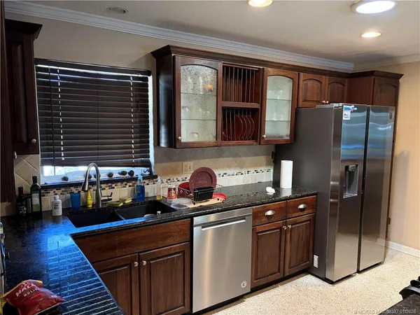 a kitchen with stainless steel appliances granite countertop a refrigerator and a stove