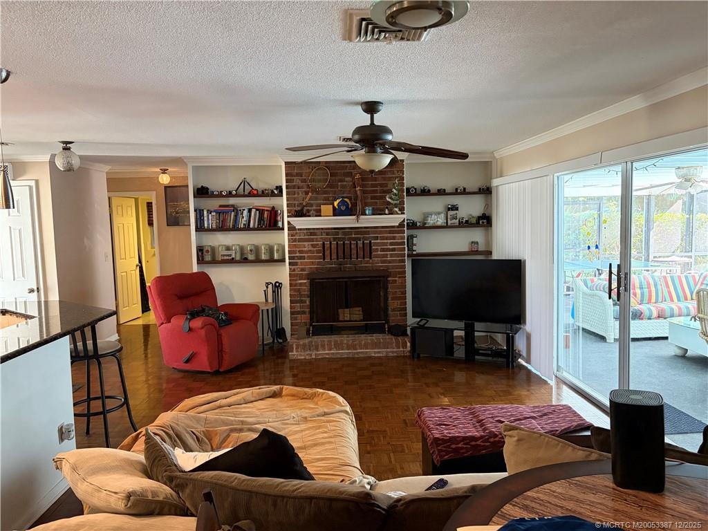 1346 Northwest Pine Ridge Trail Stuart, FL 34994 - Photo 7 of 21 a living room with furniture a flat screen tv and a fireplace
