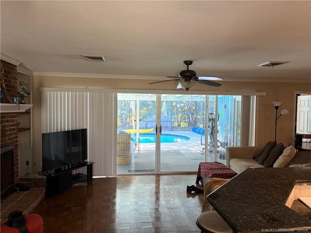 1346 Northwest Pine Ridge Trail Stuart, FL 34994 - Photo 8 of 21 a living room with furniture a flat screen tv and a fireplace