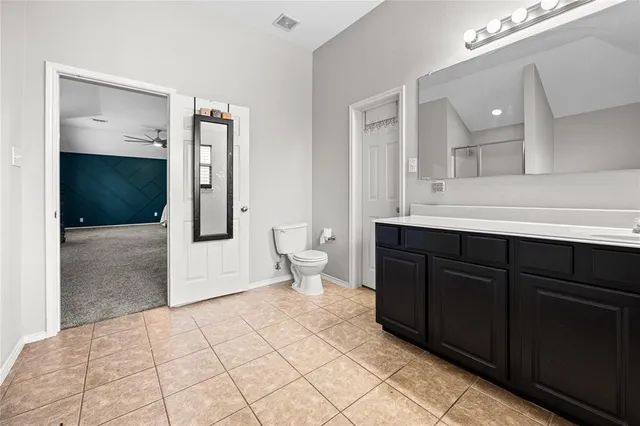 a spacious bedroom with a bed and a chandelier