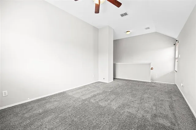 an empty room with wooden floor cabinet and windows