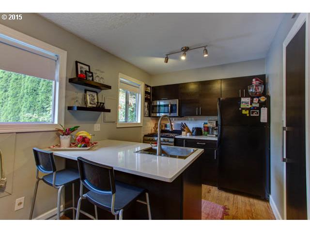 839 Southwest Broadway Drive, Unit 71 Portland, OR 97201 - Photo 6 of 15 a kitchen with a dining table chairs and a refrigerator