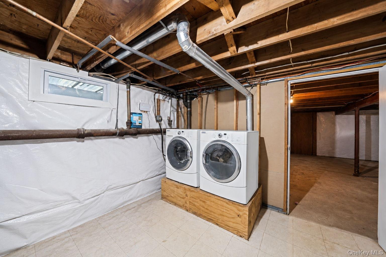 31 Crooked Hill Road Huntington, NY 11743 - Photo 22 of 32 Laundry area featuring exposed wood joists, utility piping, and a white framed window