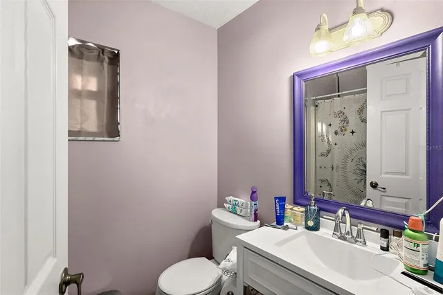 a bathroom with a sink vanity mirror and toilet