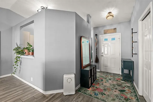 a view of a hallway with bathroom and wooden floor